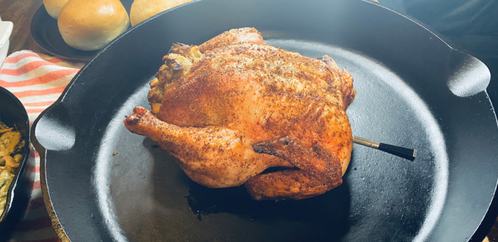 Golden roasted Springer Mountain Farms whole chicken in a cast iron skillet, perfectly seasoned and ready to serve for a family dinner.