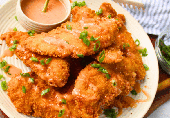 Crunchy bang bang chicken tenders drizzled with creamy spicy sauce — an easy fried chicken recipe perfect for family dinner or game day appetizer.