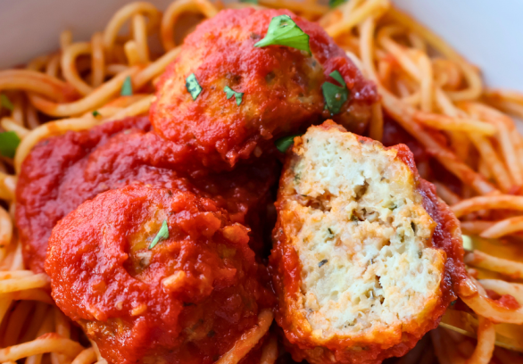 Close-up of spaghetti topped with juicy Italian chicken meatballs in marinara sauce, garnished with fresh parsley – perfect freezer-friendly dinner idea.