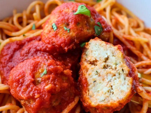 Close-up of spaghetti topped with juicy Italian chicken meatballs in marinara sauce, garnished with fresh parsley – perfect freezer-friendly dinner idea.