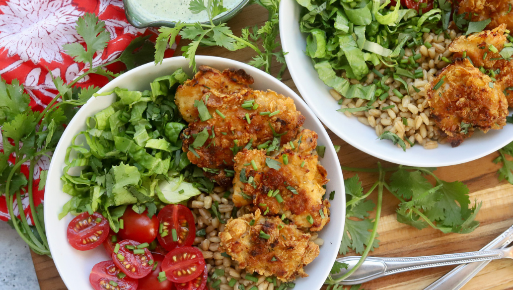Green Goddess Grain Bowl with Crispy Chicken Thighs, Cherry Tomatoes, Romaine Lettuce, and Whole Grains, served with Creamy Green Goddess Dressing – Healthy and Flavorful Meal Idea