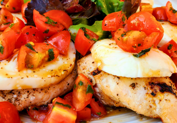 Grilled Springer Mountain Farms 4 oz boneless skinless chicken breasts topped with fresh mozzarella, cherry tomatoes, basil, and balsamic glaze for a healthy Caprese chicken recipe perfect for summer grilling.