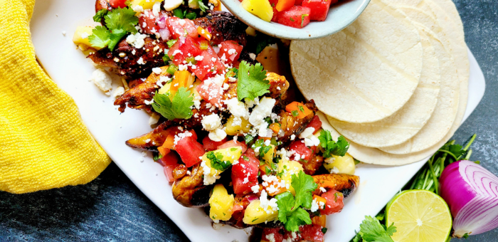 Grilled honey lime chicken tacos topped with fresh watermelon pineapple salsa and feta – tropical summer taco recipe
