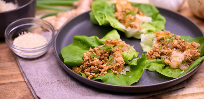 Ground chicken lettuce wraps filled with seasoned ground chicken, onions, and vegetables, served in crisp green lettuce cups.