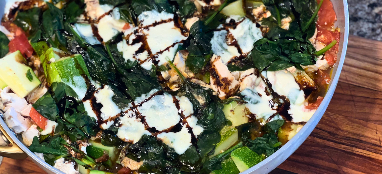 Rustic Tuscan chicken skillet made with Springer Mountain Farms poached chicken thighs, tomatoes, zucchini, baby spinach, fresh mozzarella, and drizzled with balsamic glaze.ā