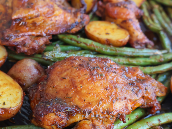 Sheet pan roasted chicken thighs with crispy baby potatoes and seasoned green beans, baked to perfection for an easy one-pan dinner