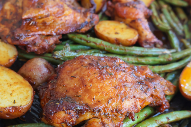 Sheet pan roasted chicken thighs with crispy baby potatoes and seasoned green beans, baked to perfection for an easy one-pan dinner"