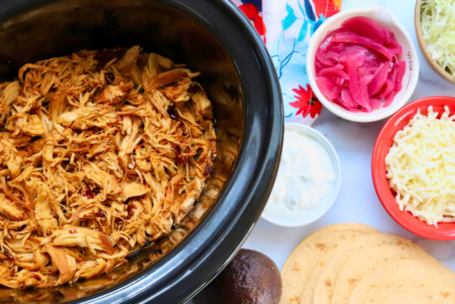 Slow cooker honey chipotle shredded chicken with taco toppings and corn tortillas – spicy chicken meal prep tacos