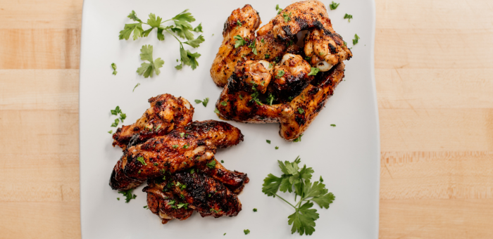 apricot chipotle glazed grilled chicken wings with sweet and smoky glaze garnished with fresh parsley