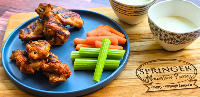 grilled fully cooked chicken wings with dipping sauces and vegetables