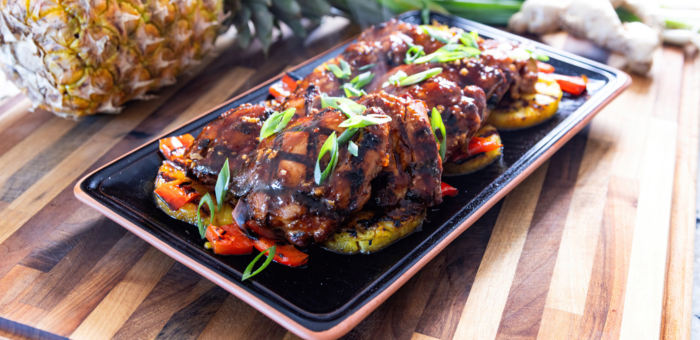 Huli Huli grilled chicken glazed with sweet and savory pineapple sauce served with grilled pineapple and peppers