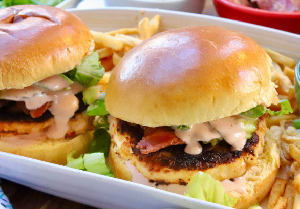 Juicy pimento cheese chicken burgers with bacon, lettuce, and spicy ranch on brioche buns served with fries