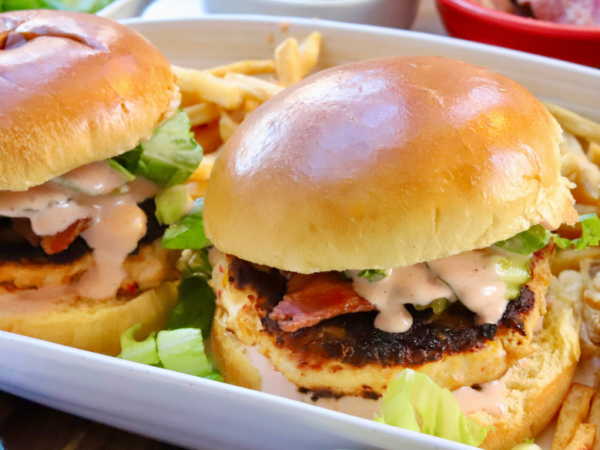 Juicy pimento cheese chicken burgers with bacon, lettuce, and spicy ranch on brioche buns served with fries