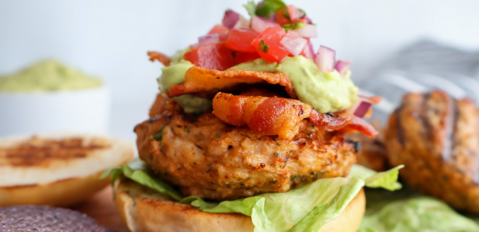 Southwestern grilled chicken burger topped with guacamole pico de gallo and crispy bacon
