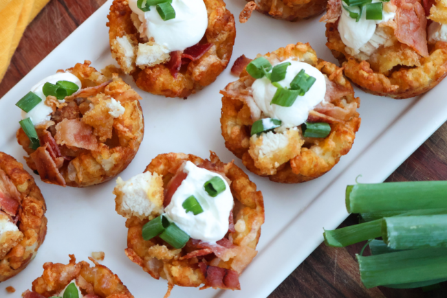 Loaded chicken bacon tater tot cups topped with sour cream and green onions