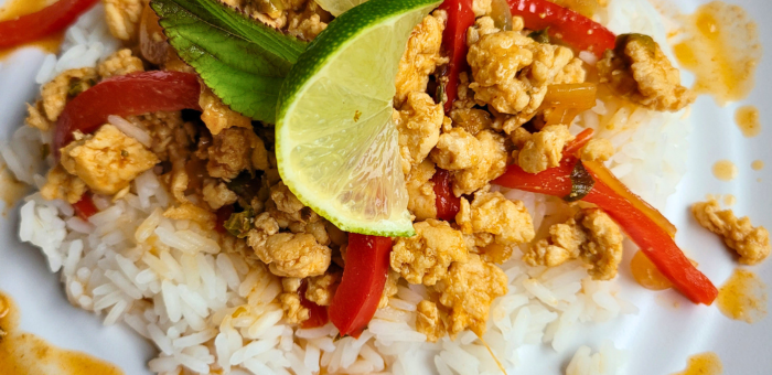 Thai basil ground chicken stir-fry served over white rice with red peppers, fresh basil, and lime for a quick weeknight dinner.